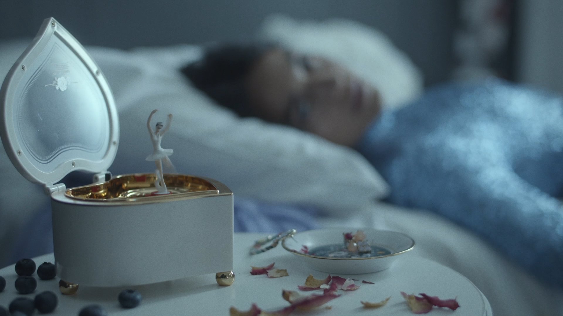 Music box with a ballerina, singer asleep in the background