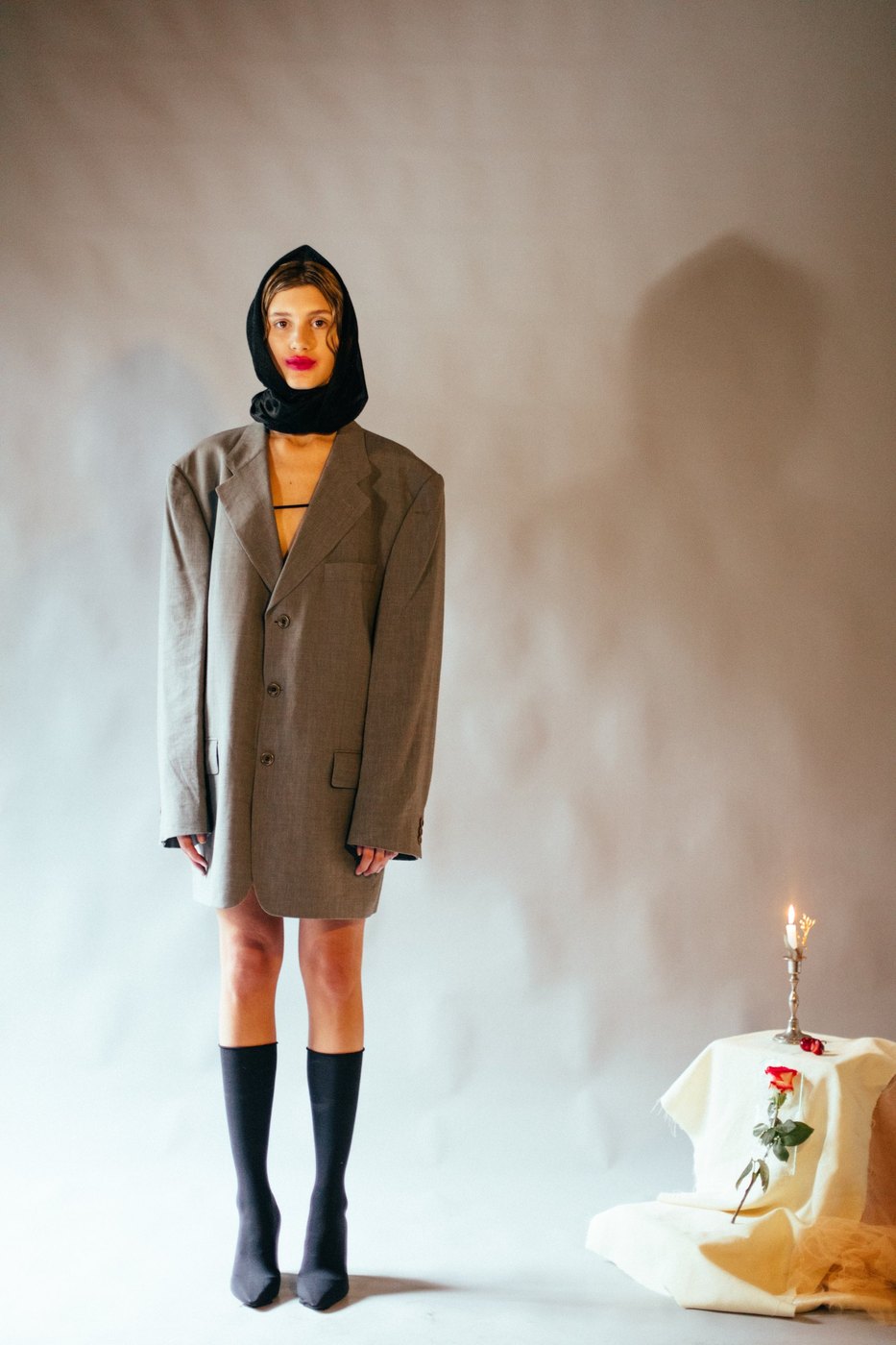 Model in an oversized grey blazer and black hood